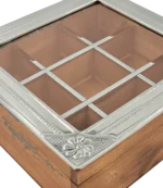 Detalle de la esquina de la caja de té Haras, con la tapa de alpaca repujada sobre la madera